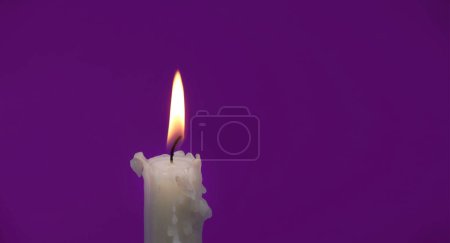 Imagen de tamaño de banner de vela encendida sobre un fondo púrpura con espacio de copia gratuito para texto