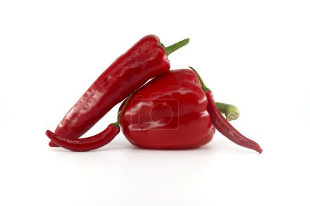 Foto de A stack of fresh chili peppers and red bell peppers isolated on white background - Imagen libre de derechos