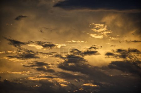 Photo for The sun's rays permeate through the clouds creating an afterglow that bathes the entire scene in an ethereal light, the sun casting long shadows and a warm golden hue over the clouds - Royalty Free Image