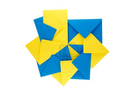 Téléchargez les photos : Collection d'enveloppes en papier bleu et jaune disposées sur un fond blanc, disposition donne l'apparence d'une géométrie tridimensionnelle éclatante qui ajoute un sentiment de profondeur et de vivacité - en image libre de droit