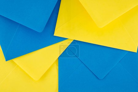Téléchargez les photos : Les enveloppes en papier bleu et jaune organisées selon un motif symétrique donnent l'apparence d'une géométrie tridimensionnelle éclatante qui ajoute un sentiment de profondeur et de vivacité. - en image libre de droit