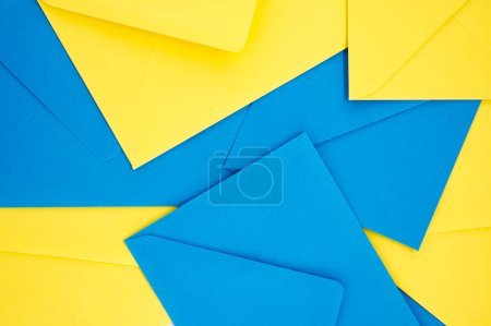 Téléchargez les photos : Les enveloppes en papier bleu et jaune organisées selon un motif symétrique donnent l'apparence d'une géométrie tridimensionnelle éclatante qui ajoute un sentiment de profondeur et de vivacité. - en image libre de droit