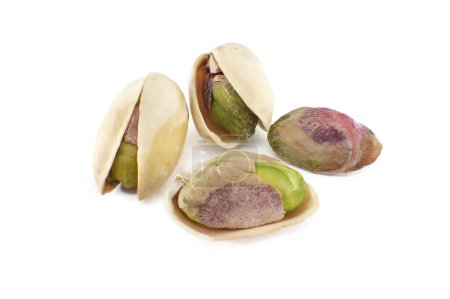 Photo for Pistachios are randomly spread across the white surface, some pistachios being in-shell and others peeled exposing the green nuts inside - Royalty Free Image