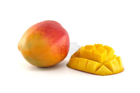 Foto de Mango maduro con piel carmesí y amarilla cerca de la mitad de un mango cortado en rodajas con carne en cubos - Imagen libre de derechos