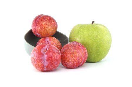 Sammlung frischer Früchte mit roten Pflaumen und leuchtend grünem Apfel vor weißem Hintergrund