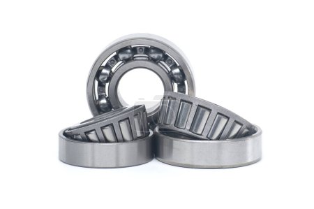 Single row tapered roller bearings and deep groove ball bearing without seal isolated on white background. Spare parts for machinery and automotive industry