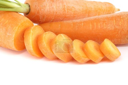 Carotte entière et morceaux tranchés, tous de couleur orange vif préparés pour la cuisson ou pour une utilisation dans un plat comme une salade ou sauté isolé sur un fond blanc