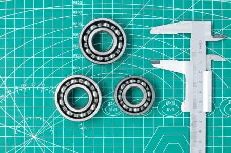 Foto de Measure caliper and roller bearings on green cutting mat with free copy space. Mechanical engineering and automotive industry - Imagen libre de derechos