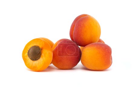 Group of fresh whole apricots and one cut in half to reveal its interior, isolated on a white background
