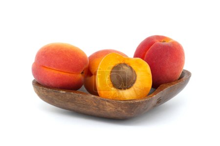 Sammlung von reifen ganzen Aprikosen und einer halbierten Aprikose, um ihr Inneres zu enthüllen, isoliert auf weißem Hintergrund