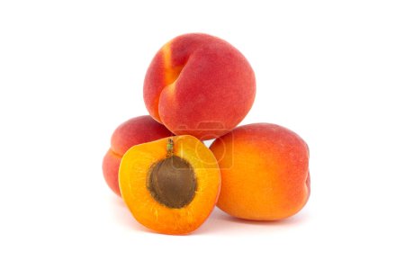 Pile of ripe apricots and one sliced in half to showcase its succulent interior, isolated on a white background
