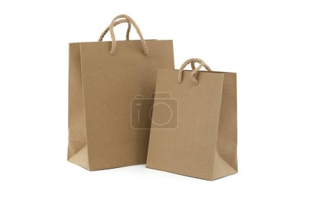 Two brown paper shopping bags with handles on a white background, perfect for marketing, retail, and eco-friendly packaging concepts.