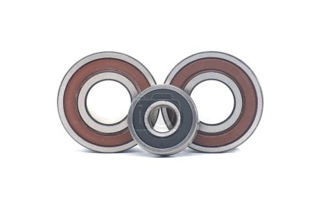 Deep groove ball bearings with rubber seals, each of different sizes, aligned vertically isolated on white background