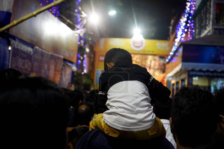 Photo for Little Boy enjoying pandal hopping upon his father's shoulder - Royalty Free Image