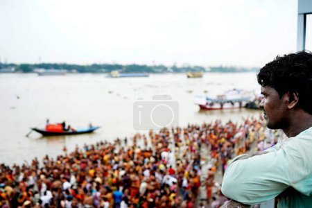 Téléchargez les photos : Homme observant la vue du Ganga Ghat Mahalaya Trapan depuis le pont supérieur - en image libre de droit