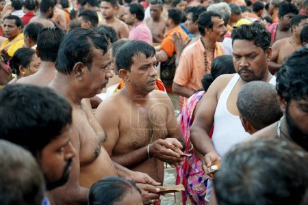 Téléchargez les photos : Exécution du rituel Tarpan dans une foule immense à Kolkata Ganga Ghat pendant Mahalaya Time - en image libre de droit