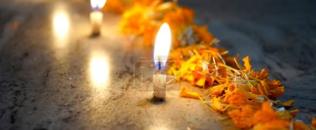 Téléchargez les photos : Bougie simple soufflant, décorée avec des fleurs de souci pour célébrer le festival - en image libre de droit