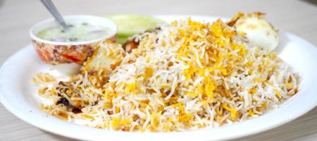 Téléchargez les photos : Kolkata spécial poulet Biryani servi avec Raita - en image libre de droit