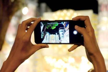 Téléchargez les photos : Visiteur en cliquant sur Mudiali Durga Puja Pandal avec son téléphone intelligent - en image libre de droit