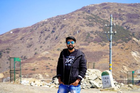 Photo for Young Aged boy wearing black jacket and sunglass Posing in Mountain during his travel - Royalty Free Image