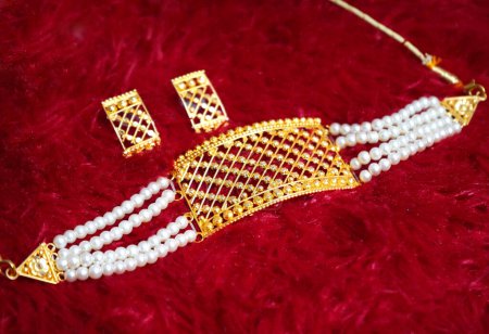 Gargantilla de imitación de oro y pendientes en terciopelo fondo rojo