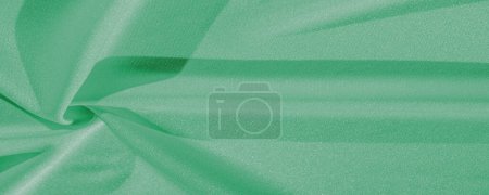 Green silk. Smooth elegant green luxury silk fabric can be used as abstract background with copy space, close up. colorful texture