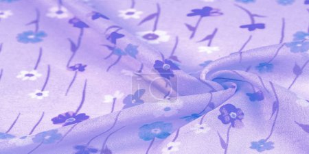 Foto de Tela de seda, flores pequeñas sobre un fondo lila, una delgada tira de tono azul con un estampado. Diseño floral. Textura de fondo - Imagen libre de derechos