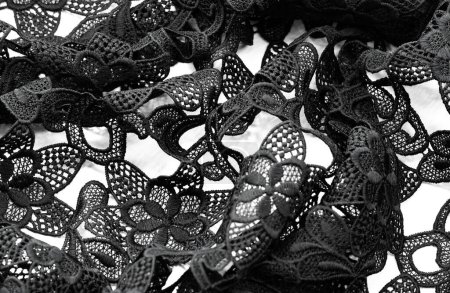 Spitzenstoff in schwarz. Spitze aus reiner Baumwolle mit floralem Muster, verziert mit Stickereien. Leichte Transparenz. Texturiert. Hintergrund. Muster