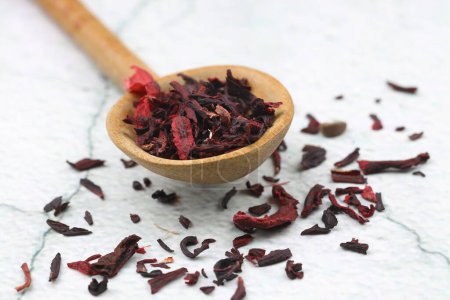 Karkade tea. Hibiscus tea leaves in wooden spoon isolated on white background. File contains clipping path. Top view.