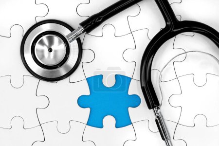 stéthoscope noir sur puzzle blanc avec pièce manquante et espace de copie bleu, image de concept médical représente un diagnostic manquant.