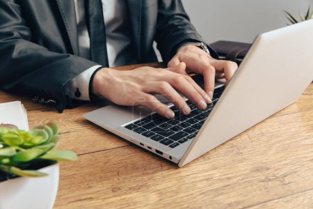 Businessman typing on laptop at work des