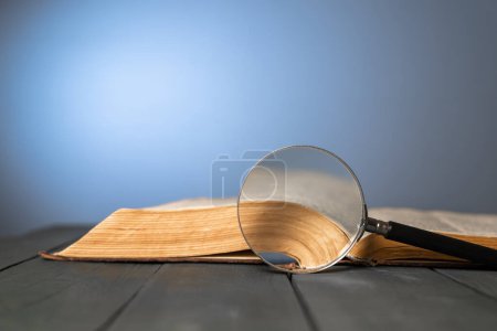 Book and magnifying glass on the tabl-stock-photo