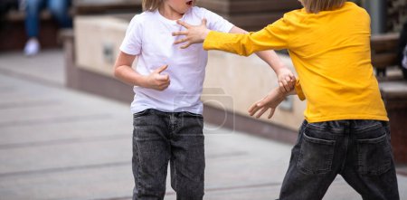 Foto de Pequeños niños peleando en el stree - Imagen libre de derechos