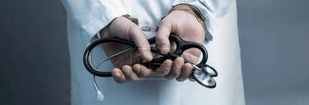 Arzt legt Handschellen mit Stethoskop an