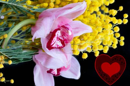 Foto de Close up of beautiful  orchids  and mimosas  bouquet  and heart - Imagen libre de derechos
