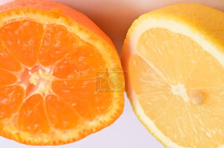 Téléchargez les photos : Ripe tangerine and lemon halves, close up - en image libre de droit