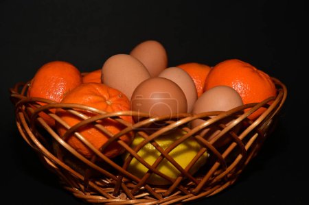 Photo for Easter holiday, eggs, fruits in  basket on black background - Royalty Free Image