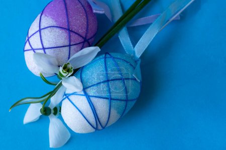 Foto de Beautiful  snowdrops  and  easter eggs on blue background - Imagen libre de derechos