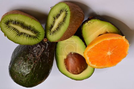 Photo for Kiwis and avocados, orange  on a white background - Royalty Free Image