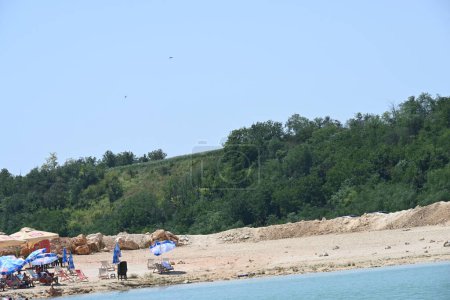 Téléchargez les photos : Chaises longues et parasols sur la belle rive du lac - en image libre de droit