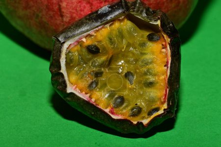 Foto de Vista de cerca de granada fresca madura con fruta de la pasión sobre fondo verde - Imagen libre de derechos