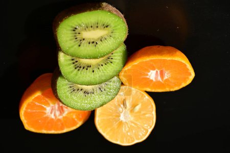 Téléchargez les photos : Kiwi tranché, fruits à l'orange et au citron sur fond noir - en image libre de droit