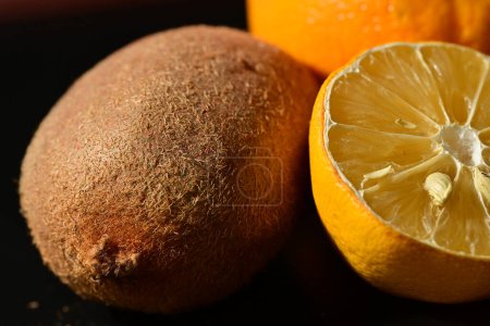Téléchargez les photos : Oranges, kiwi fruits frais mûrs sur fond noir - en image libre de droit