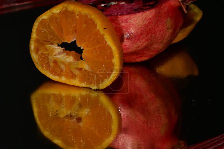Photo for Pomegranate, orange  fresh ripe fruits on a black background - Royalty Free Image