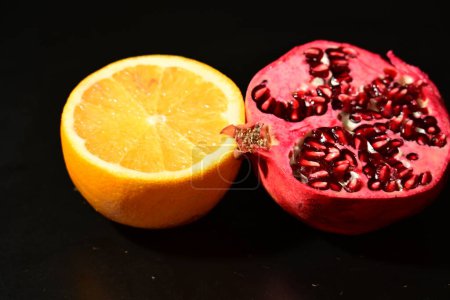 Téléchargez les photos : Grenade rouge fraîche juteuse et mûre à l'orange coupée en deux - en image libre de droit