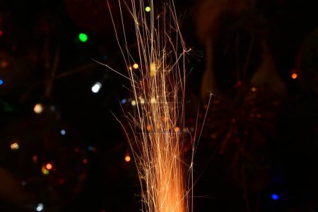 Photo for Burning sparkler on blurred festive christmas background - Royalty Free Image