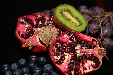 Foto de Frutas y bayas frescas maduras sobre fondo negro - Imagen libre de derechos