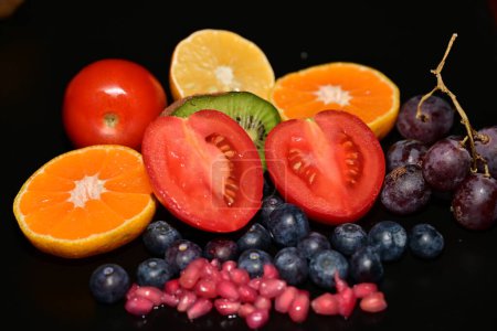 Photo for Fresh fruits and tomatoes  on the black background - Royalty Free Image