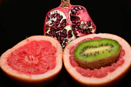 Foto de Fruta fresca cortada en trozos sobre un fondo negro - Imagen libre de derechos