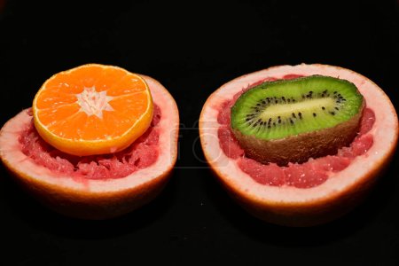 Téléchargez les photos : Fruit orange tranché sur fond noir - en image libre de droit